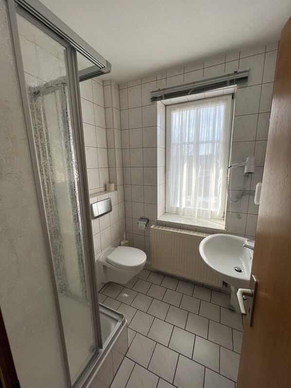 Un baño con ducha, inodoro y lavamanos.