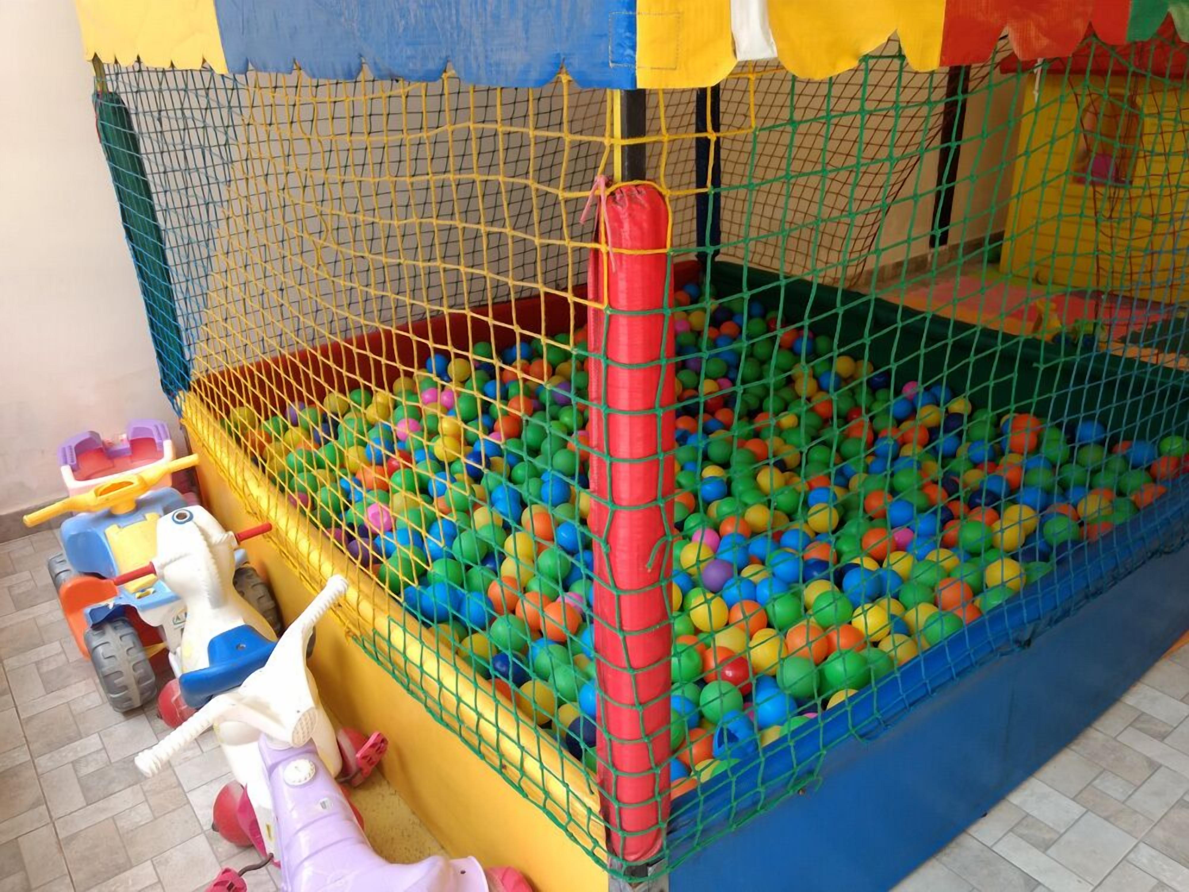 A children's play area with a ball pit, a slide, and a small toy car.