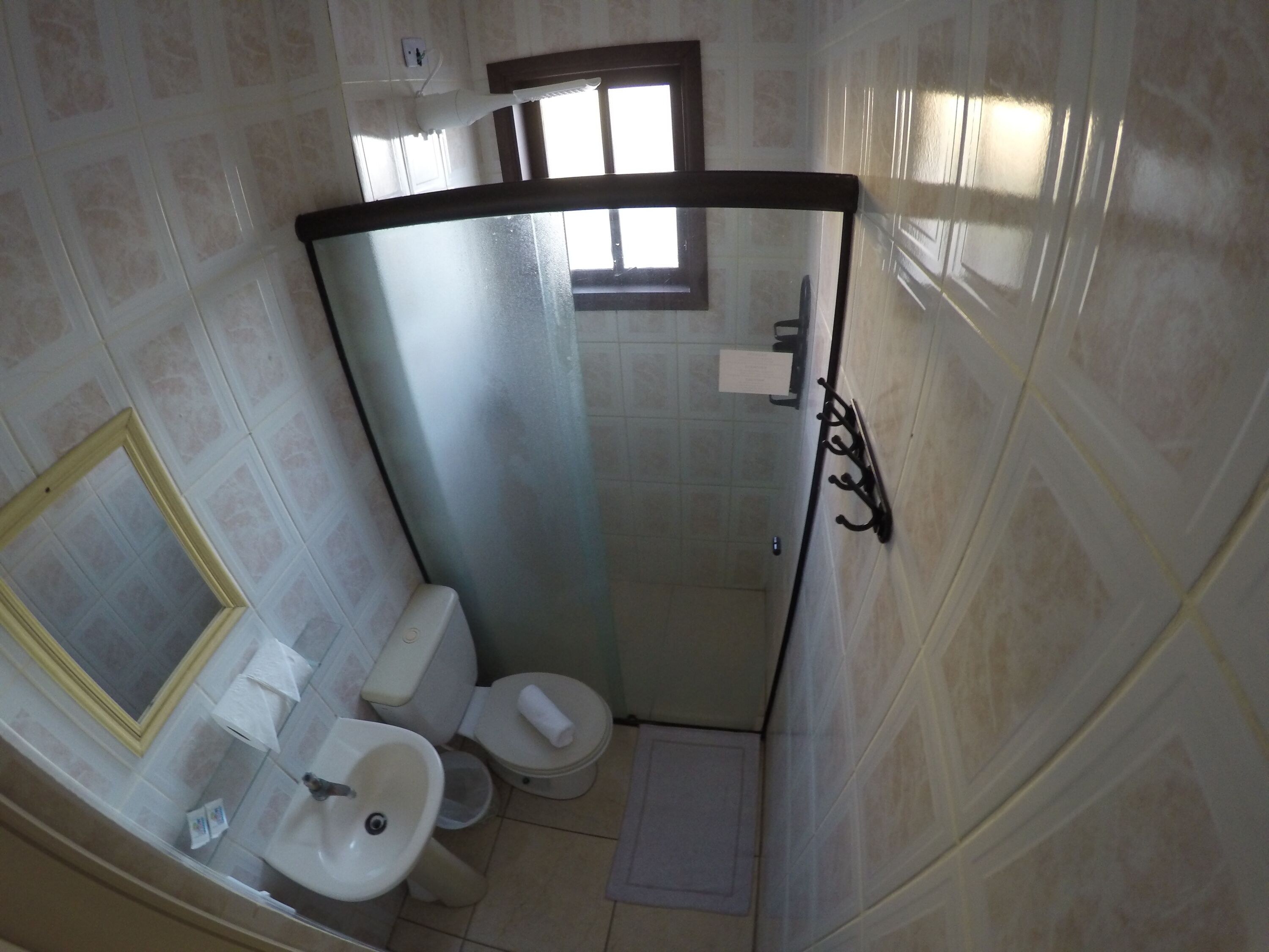 A compact bathroom with a toilet, sink, and shower area.