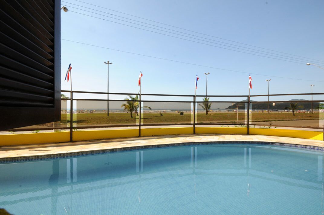 A swimming pool with a view of a beach and flags.