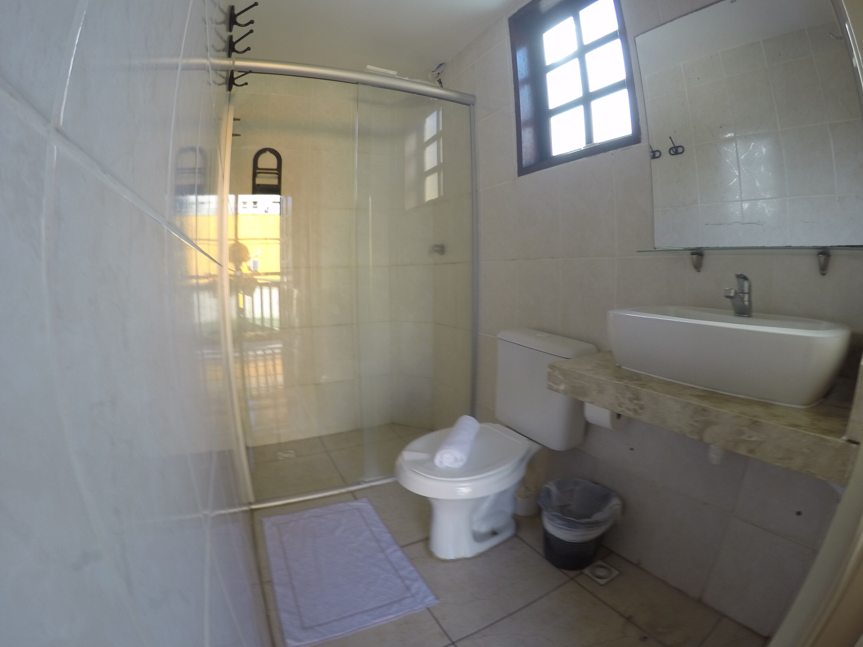 A bathroom with a toilet, sink, and shower area.