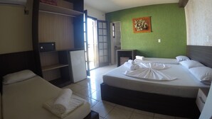 A hotel room with two beds, a wardrobe, a small table, and a green wall with a decorative piece. - Pousada do Francês (Bertioga)
