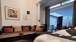 Une chambre d’hôtel moderne, dotée d’un grand lit, d’un canapé, d’une table à manger et offrant une vue sur l’extérieur.