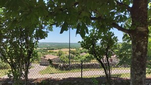 A fenced property with a stone wall, a small building, and a view of a rural landscape. - Gite du Fourbas - renovated in 2025 - with swimming pool (Belmont-Sainte-Foi)