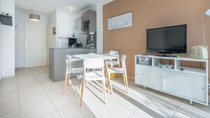 Un espacio de estar moderno con cocina, comedor y mueble de entretenimiento.