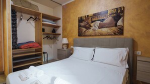 Une chambre d’hôtel avec un lit, une armoire, un tableau et une table de chevet.