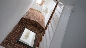 A staircase with a brick wall and a wooden railing.