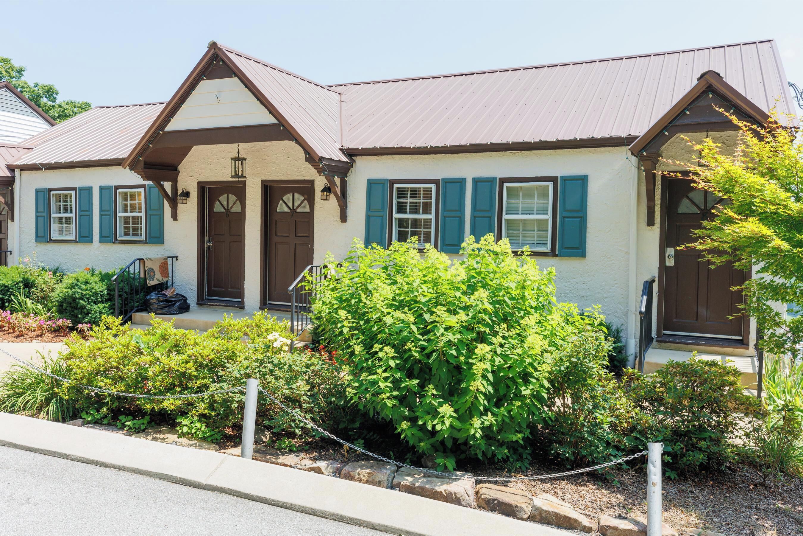 A two-story house with a gabled roof, a front porch, and a well-maintained garden.