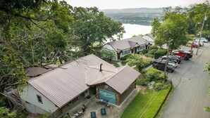 A riverside inn with a patio area, a parking lot, and a view of a lake.