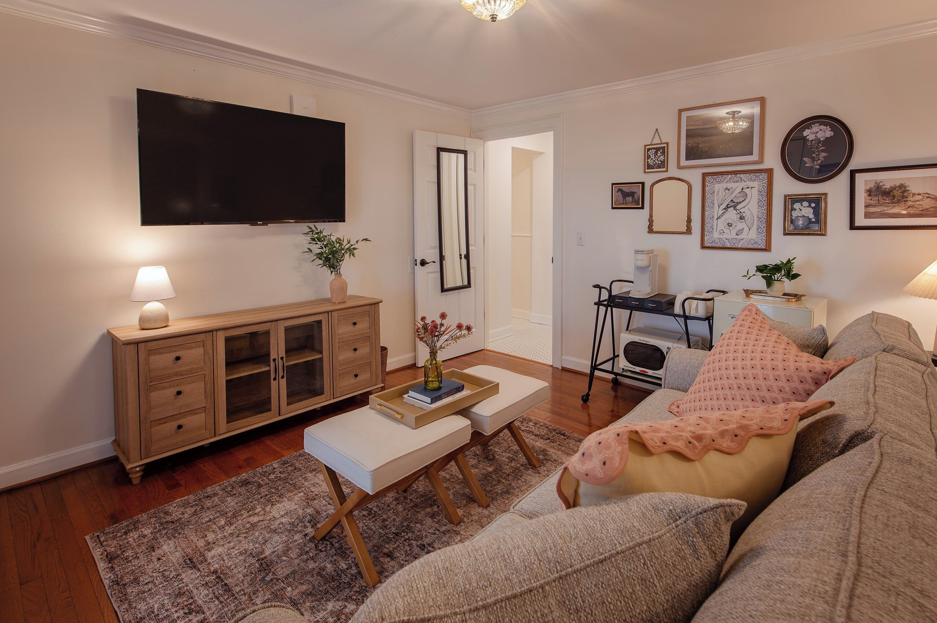 A living room with a TV, wooden cabinet, and a sofa.