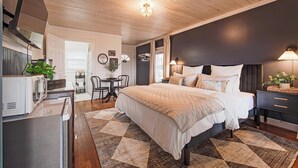 A modern bedroom with a large bed, bedside tables, a desk, and a chair.