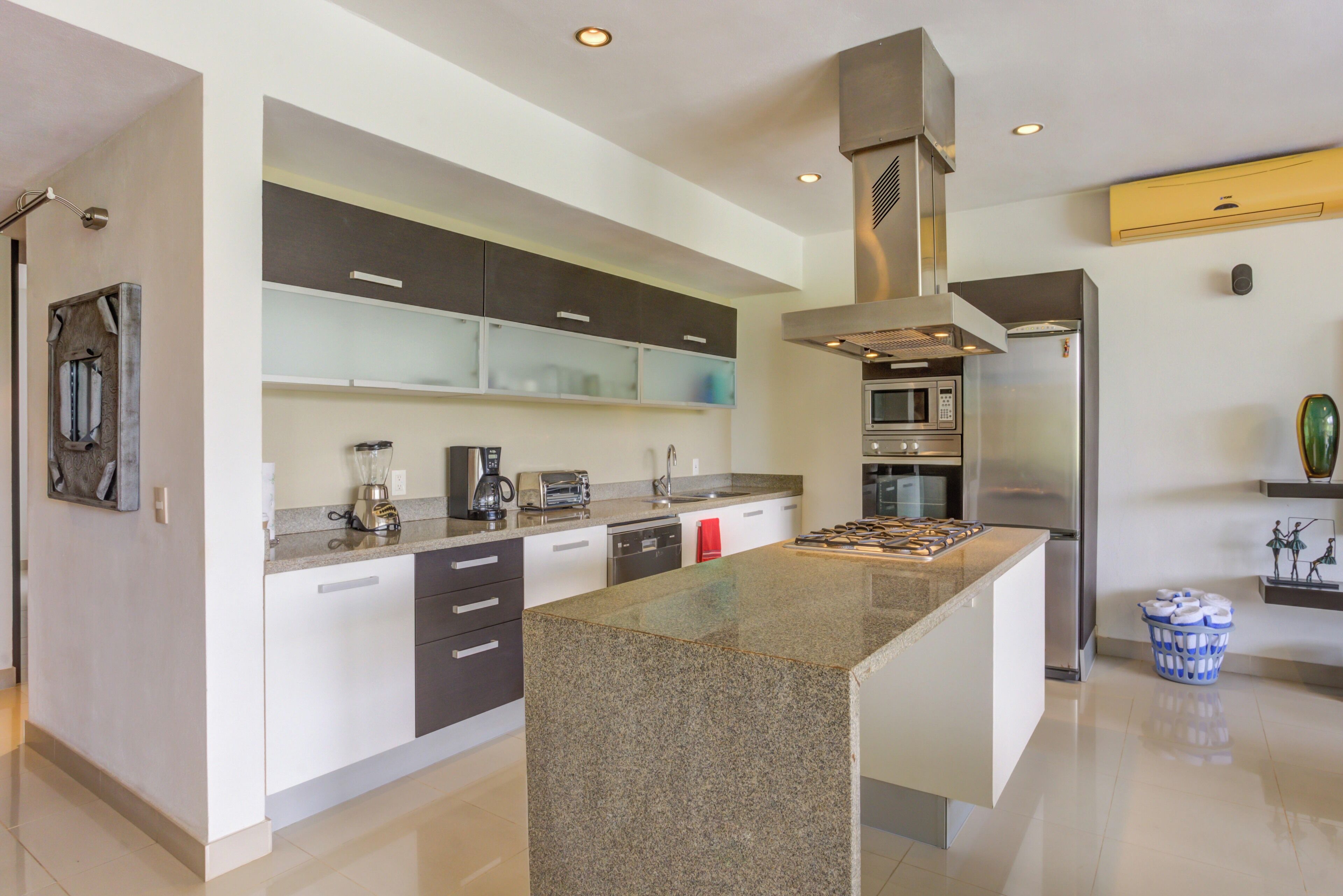 A modern kitchen with granite countertops, stainless steel appliances, and a central island.