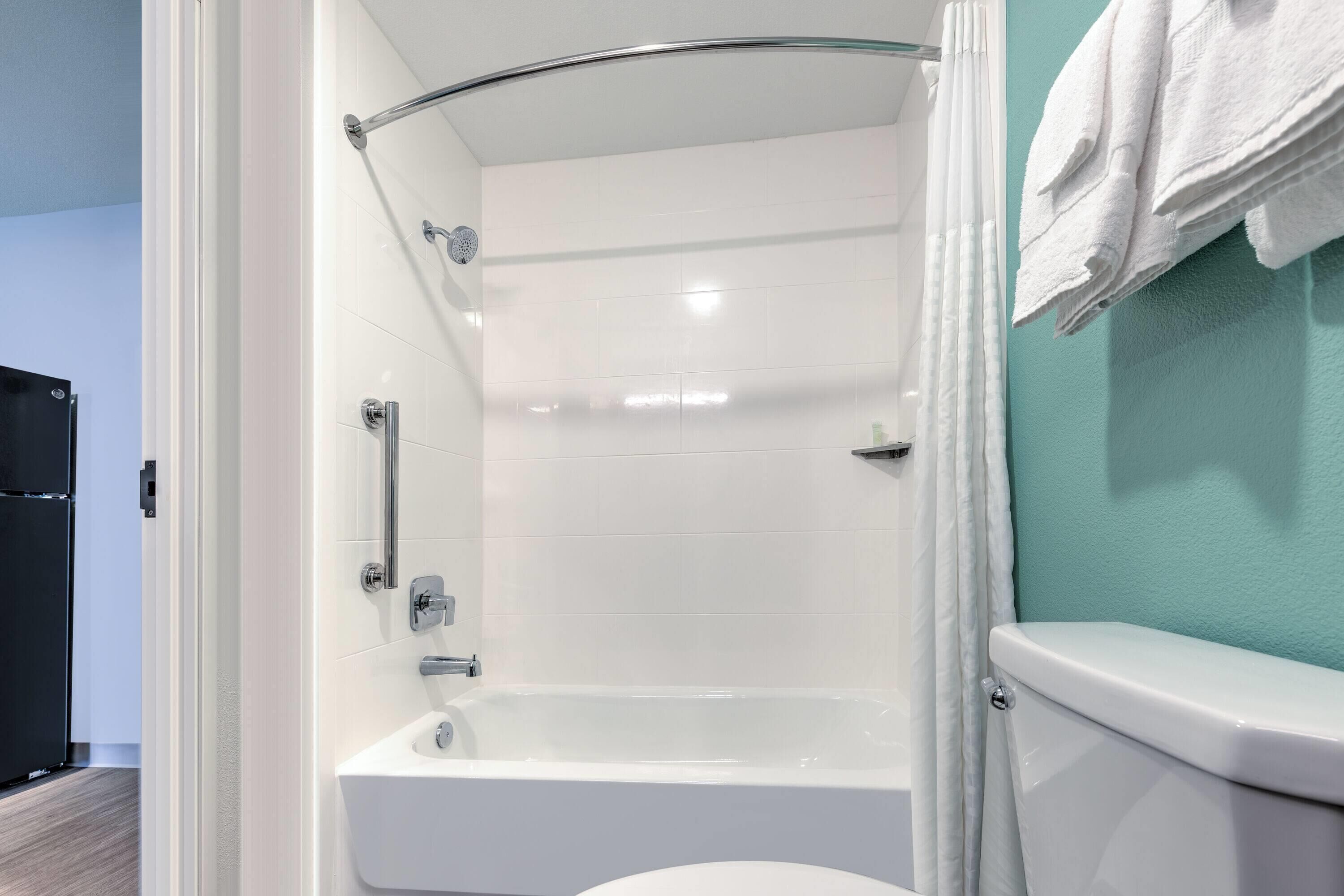 Un bagno moderno con una vasca da bagno bianca, un water e una zona doccia.