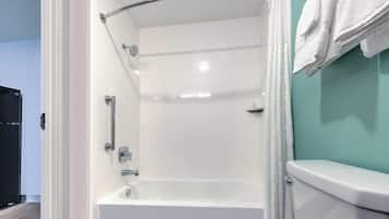 Un baño moderno con una bañera blanca, un inodoro y una zona de ducha.