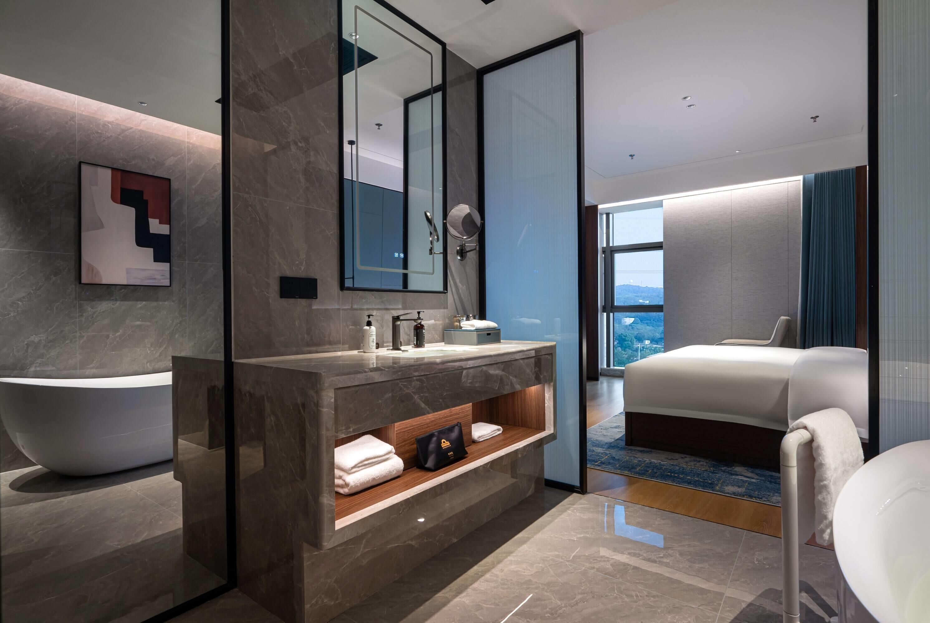A modern bathroom with a large bathtub, a vanity with a mirror, and a shower area.