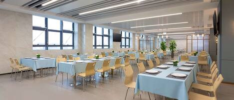 A spacious conference room with multiple tables and chairs, large windows, and a modern ceiling design.