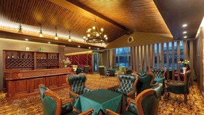 A spacious room with a wooden ceiling, a bar area with shelves, and a seating area with green upholstered chairs and a table. - Days Hotel By Wyndham Harbin Qunli (Harbin)