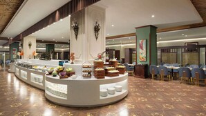 A buffet area with a variety of food items and a seating arrangement with tables and chairs. - Days Hotel By Wyndham Harbin Qunli (Harbin)