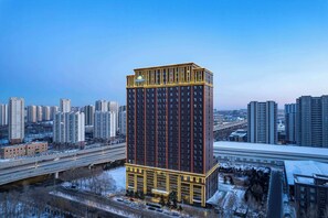 Ein Hochhaus-Hotel mit modernem Design, das ein markantes Logo oben trägt.