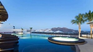 Una piscina con vistas a montañas y palmeras.