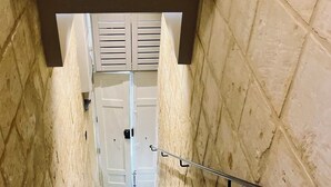 A staircase with a handrail, leading to a white door with shutters. - Charming studio with WiFi and AC in enchanting Il-Furjana (Il-Furjana)