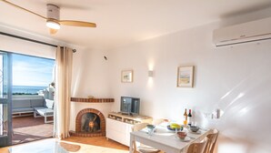 A modern living room with a fireplace, dining table, and a TV. - Las Palmas 20c - El Oasis de Capistrano (Nerja)