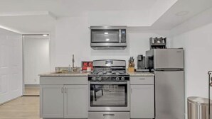 Una cocina moderna con electrodomésticos de acero inoxidable, incluyendo un microondas, horno y refrigerador.