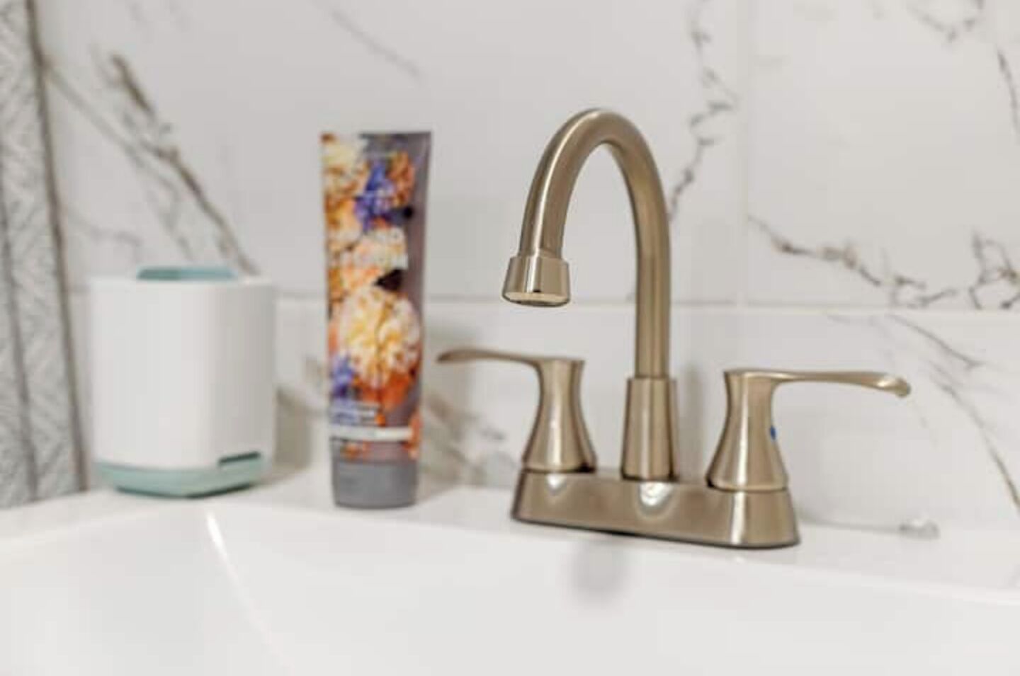 A bathroom sink with a modern faucet and a hand soap dispenser.