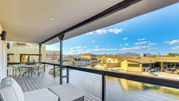 A balcony with outdoor seating and a view of a residential area and mountains. - Multi-Home Retreat on Colorado River w/ Boat Dock! (Parker)