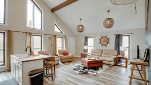 A spacious living room with a large window, a kitchen area, and a cozy seating arrangement. - Lakefront Guntersville Apt w/ Shared Dock! (Guntersville)