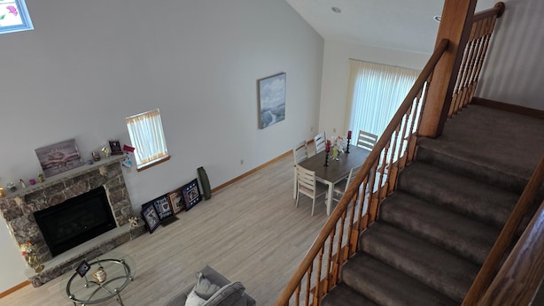 A spacious living room with a fireplace, a dining area, and a staircase. - Charming 3-bedroom house MUST BE A LAND OWNER IN EAGLE ROCK RESORT (Hazleton)