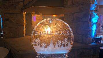 A glass igloo with "EAGLE ROCK" engraved on it, set against a stone wall backdrop.