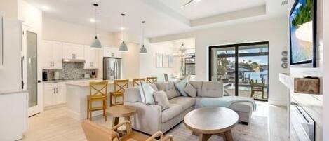 A modern kitchen with white cabinets, a central island, and pendant lighting.