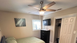 A bedroom with a bed, a desk, a chair, a TV, a ceiling fan, a window, and a closet. - Soldier/Family Charming 3bed/2bath (Columbus)