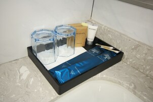 Een badkamerrek met toiletartikelen, waaronder een douchemutsje, conditioner en een tandenborstel.