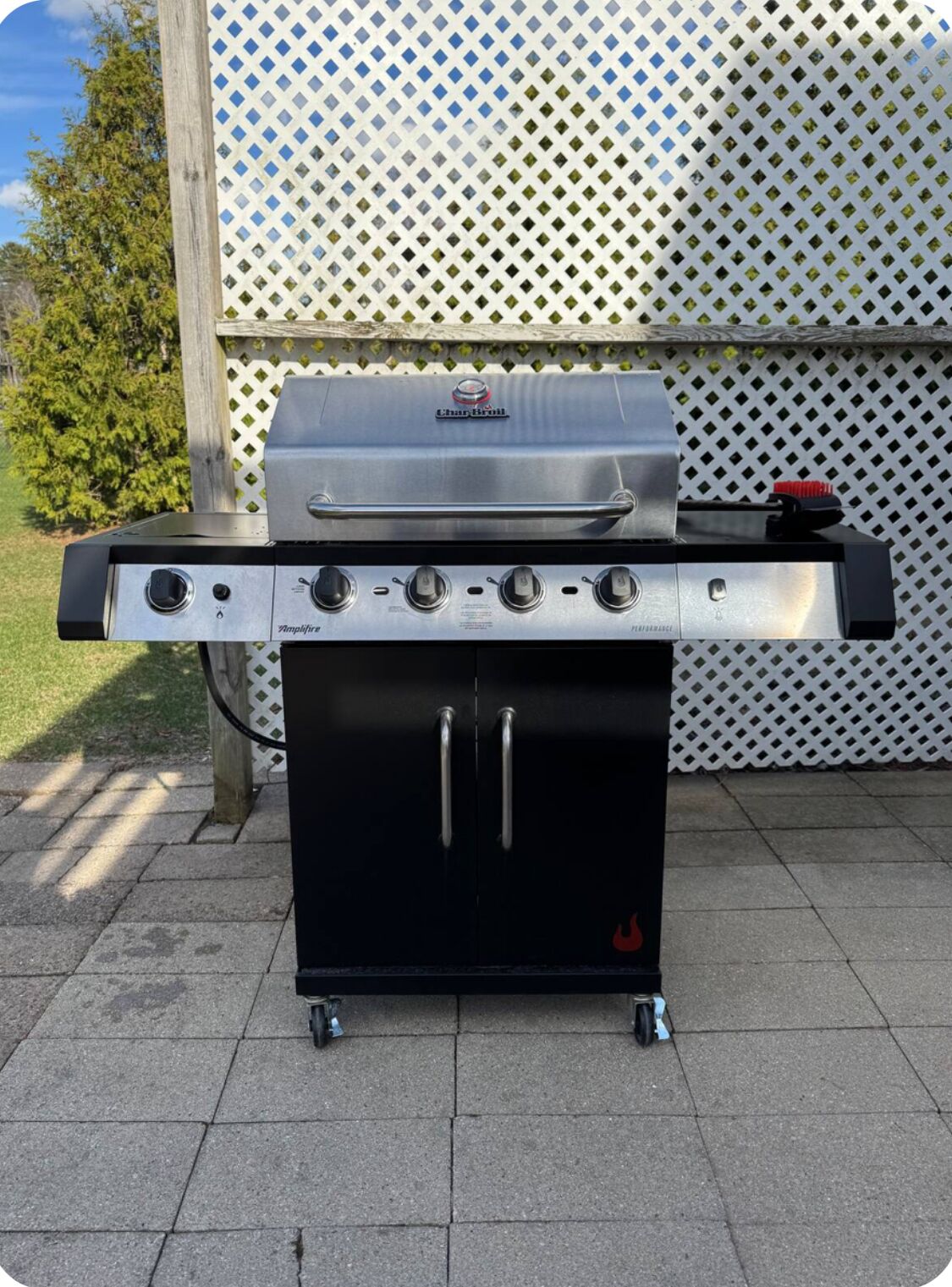 Ein tragbarer Gasgrill mit vier Brennern, einem Seitenbrenner und einem Stauraumschrank.