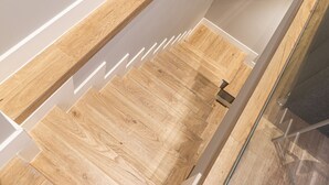A wooden floor with a glass railing in a corner. - Waou Essence III Tirso Molina - Corta Duración (Madrid)