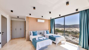 A modern hotel room with two beds, a balcony with a view, and a large window. - Villa Maranga in Kalkan (Kaş)