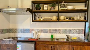 Eine Küche mit Holzausstattung, einem Edelstahl-Kühlschrank, einem Gasherd und einer gefliesten Spritzschutzwand.