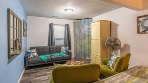 A small, cozy room with a sofa, two chairs, a cabinet, and a fan. - MermaidManorCarriageHouse|ScreenedSaltwaterPool&Hottub|Sleeps6|1DogOK (Homosassa)