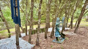 A statue of a woman in a dress and hat, surrounded by trees and a gravel path. - MermaidManorCarriageHouse|ScreenedSaltwaterPool&Hottub|Sleeps6|1DogOK (Homosassa)
