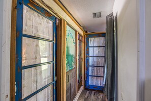 A hallway with wooden doors, some with glass panels, and a visible vent on the ceiling. - MermaidManorCarriageHouse|ScreenedSaltwaterPool&Hottub|Sleeps6|1DogOK (Homosassa)