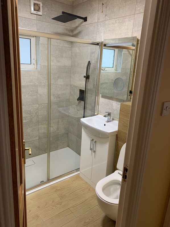 A modern bathroom with a glass shower enclosure, a white sink, and a toilet. - Spacious 4-bedroom house in Clonee with WiFi

Owner is staying @ Same Property (Clonee)