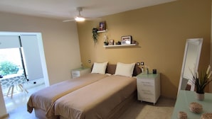 Una camera da letto con un letto, comodini, una cassettiera, uno specchio e uno scaffale con oggetti decorativi.