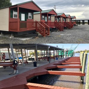 A row of small, single-story cabins with red railings and a covered dock area. - The Delacroix Lodge (Delacroix)