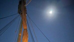 A night sky with stars and a bright moon.
