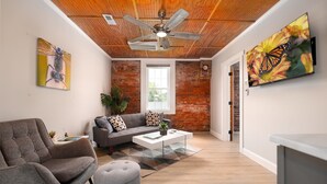 A living room with a gray sofa, a gray armchair, a coffee table, and a ceiling fan. - Modern meets Classic: Cozy condo on Smith River (Bassett)
