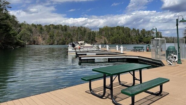 A lakeside park with picnic tables, a dock, and boats. - Modern meets Classic: Cozy condo on Smith River (Bassett)