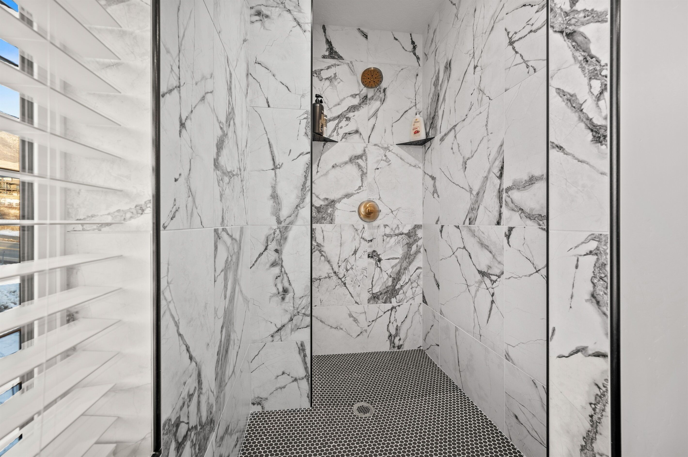 Une salle de bain moderne avec des murs en marbre et un espace douche.