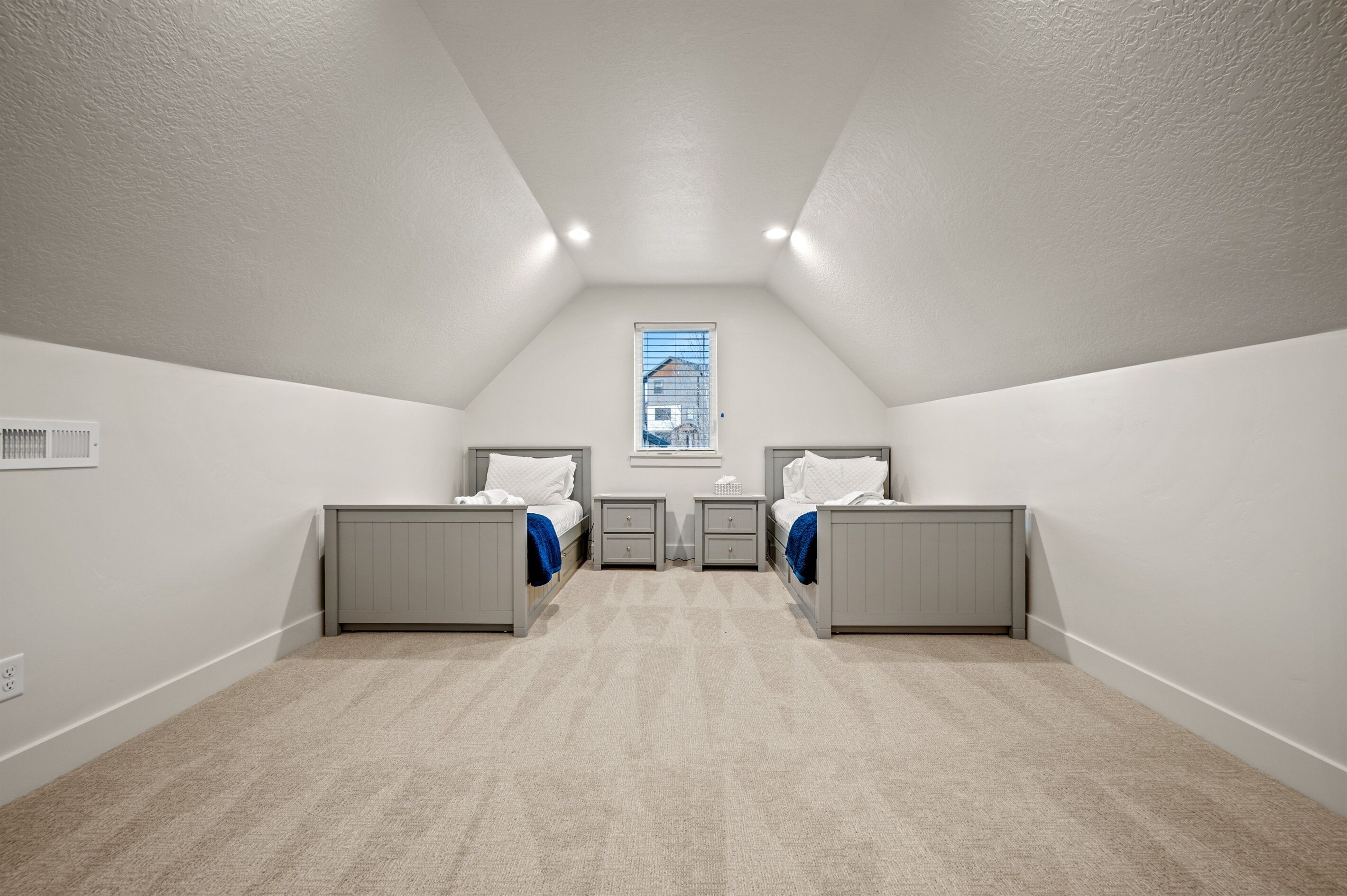 Un dormitorio con dos camas, una ventana y un radiador.